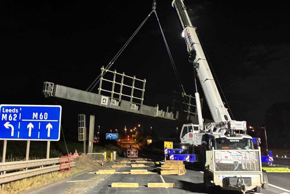 A crane removing the gantry on the M60 in July 2026